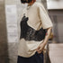 Person wearing a beige t-shirt with black graphic design in an indoor setting